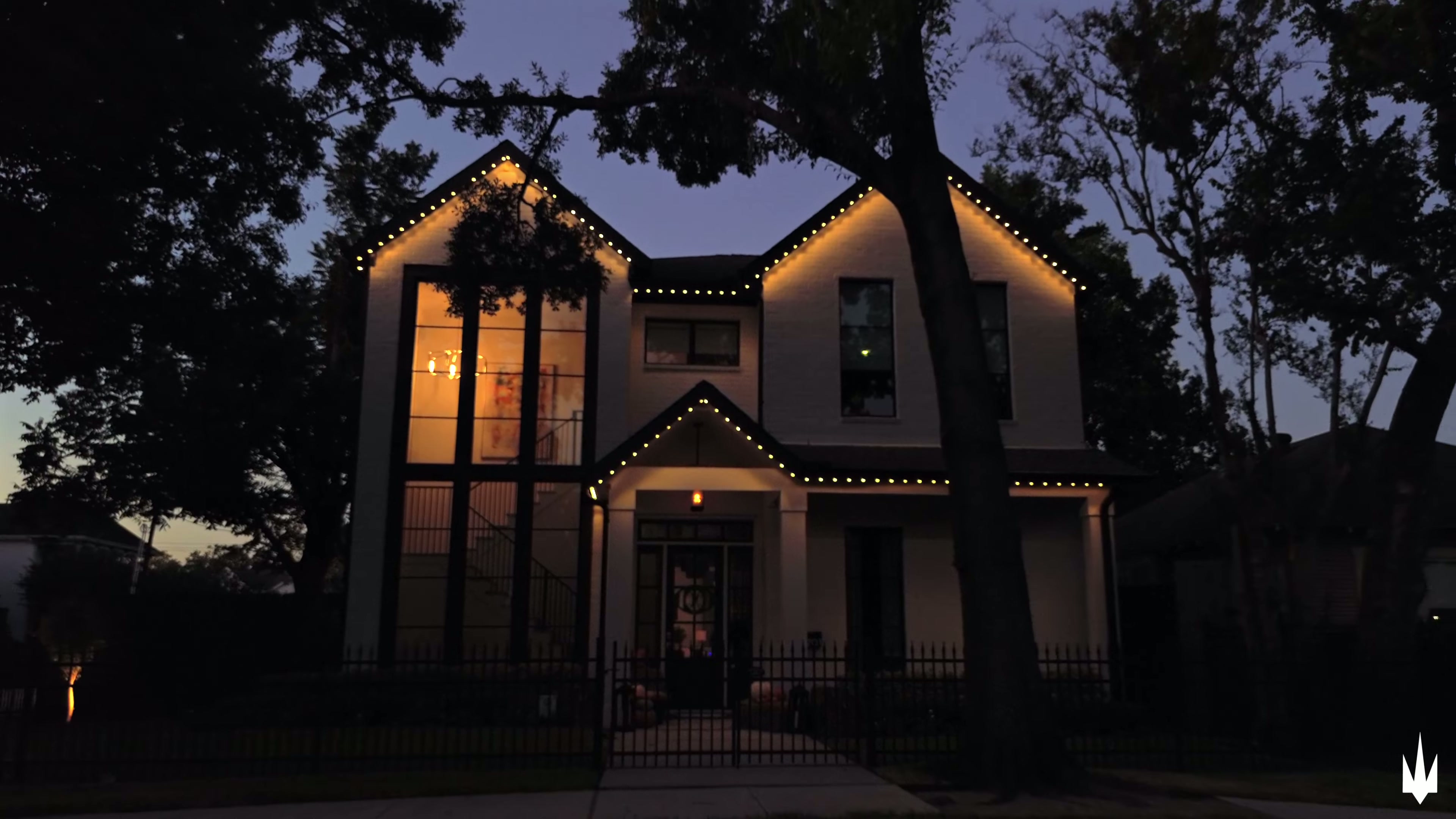 Houston home at dusk with warm white permanent roofline lighting illuminated